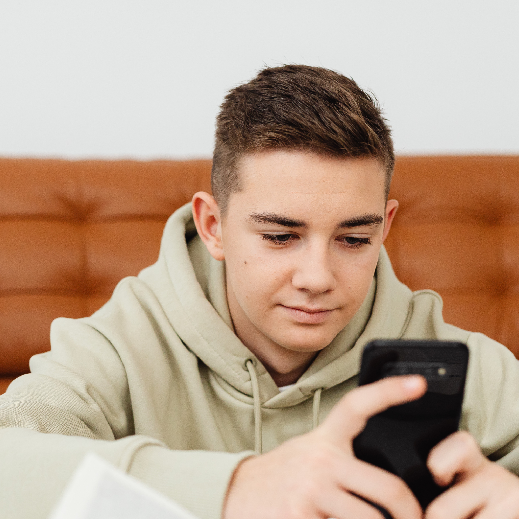 Jugendlicher schaut konzentriert auf sein Smartphone