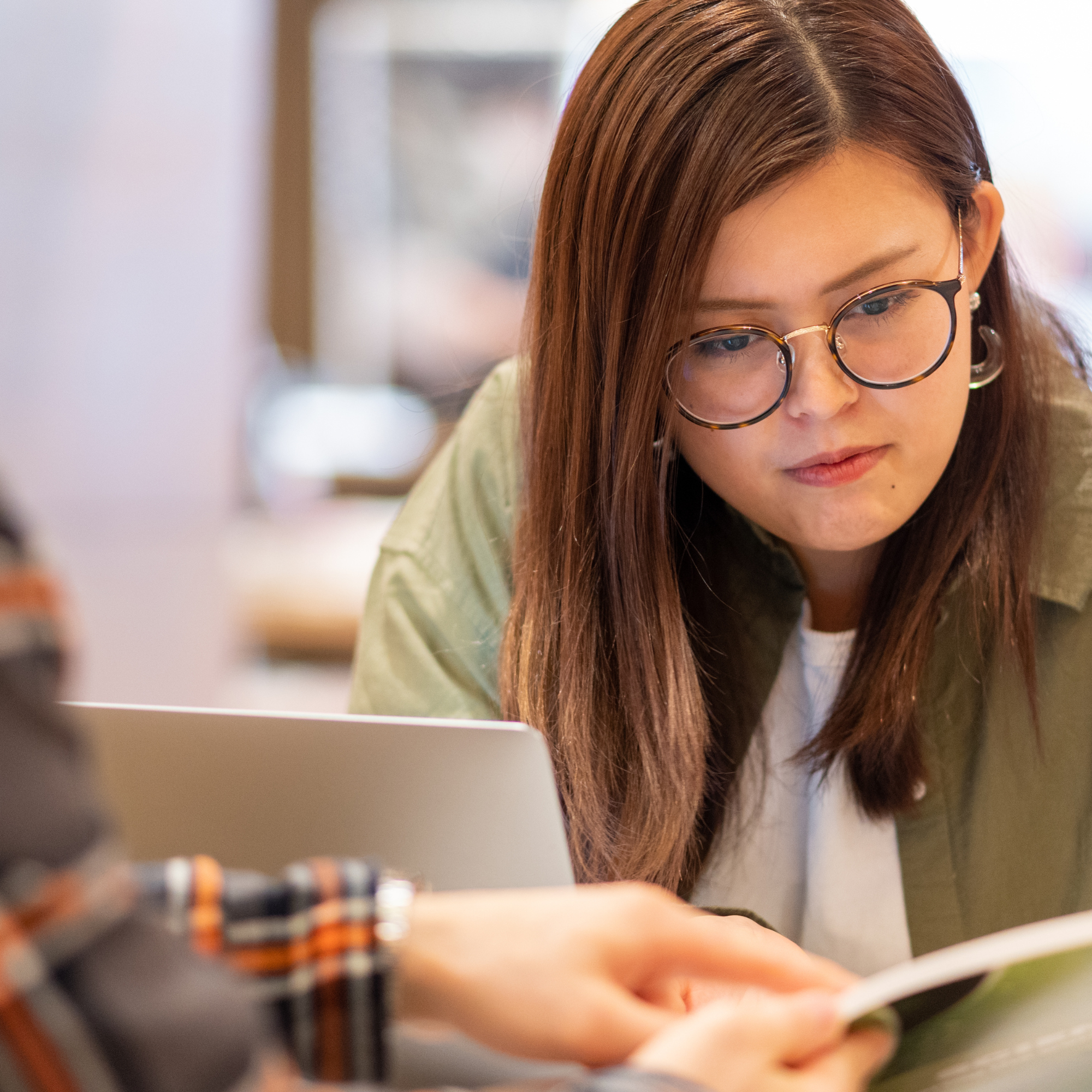 Frau mit Brille arbeitet konzentriert am Laptop